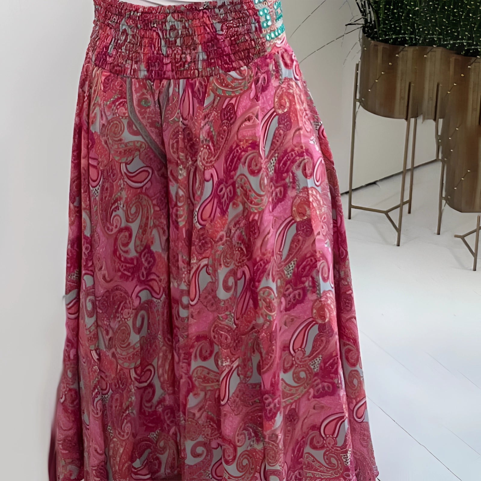 Bohemian palazzo pants in pink paisley with a wide-leg design and ethnic print, made from lightweight fabric.