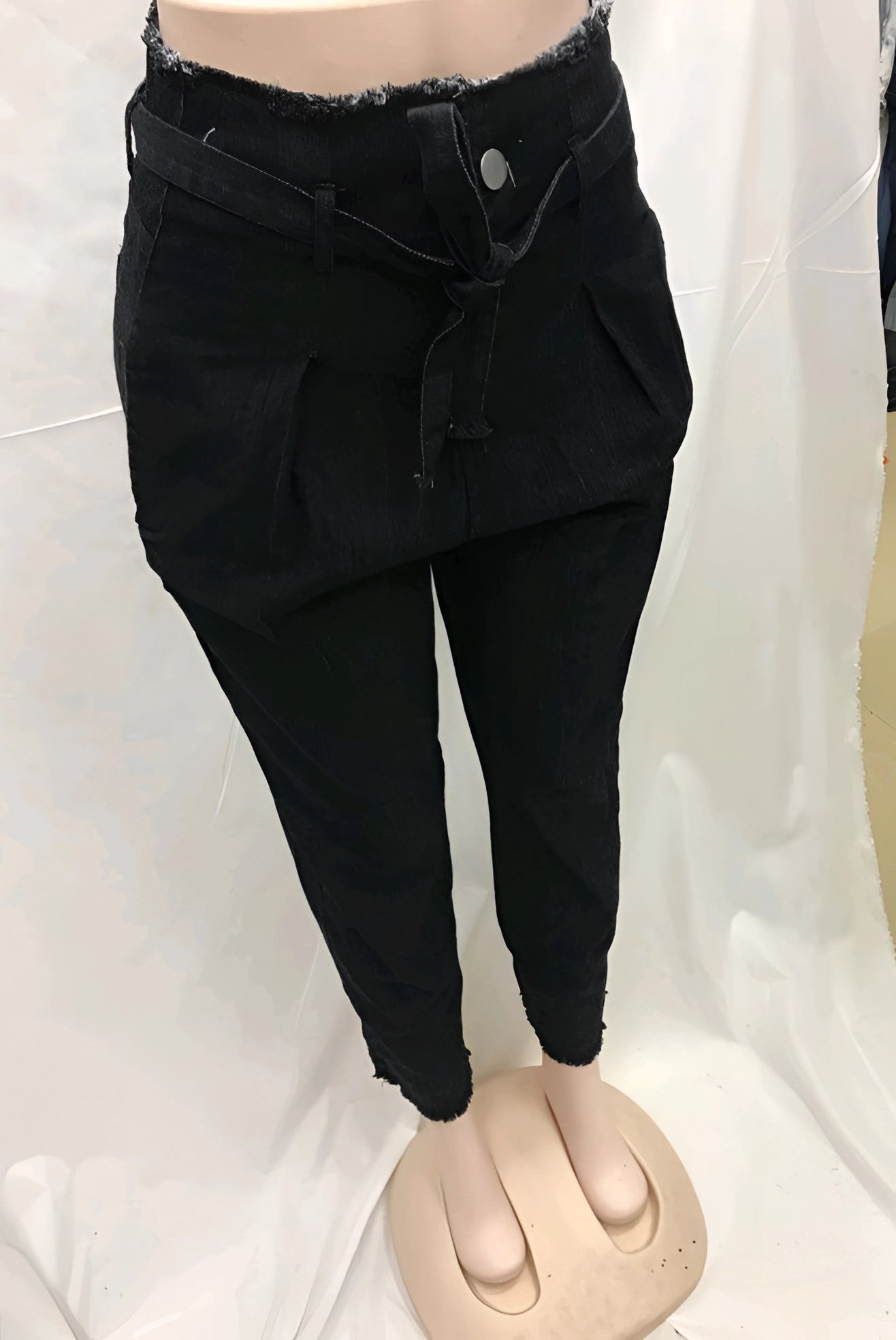 Woman wearing high-waist jeans and a cropped black tank top, urban fashion style, in black color, size 3XL, standing and showcasing the trendy outfit.