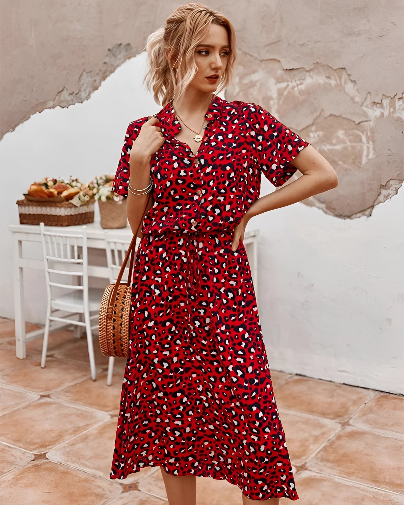 Woman wearing a red polka dot midi dress with short sleeves and a tie waist, perfect for lightweight summer fashion.