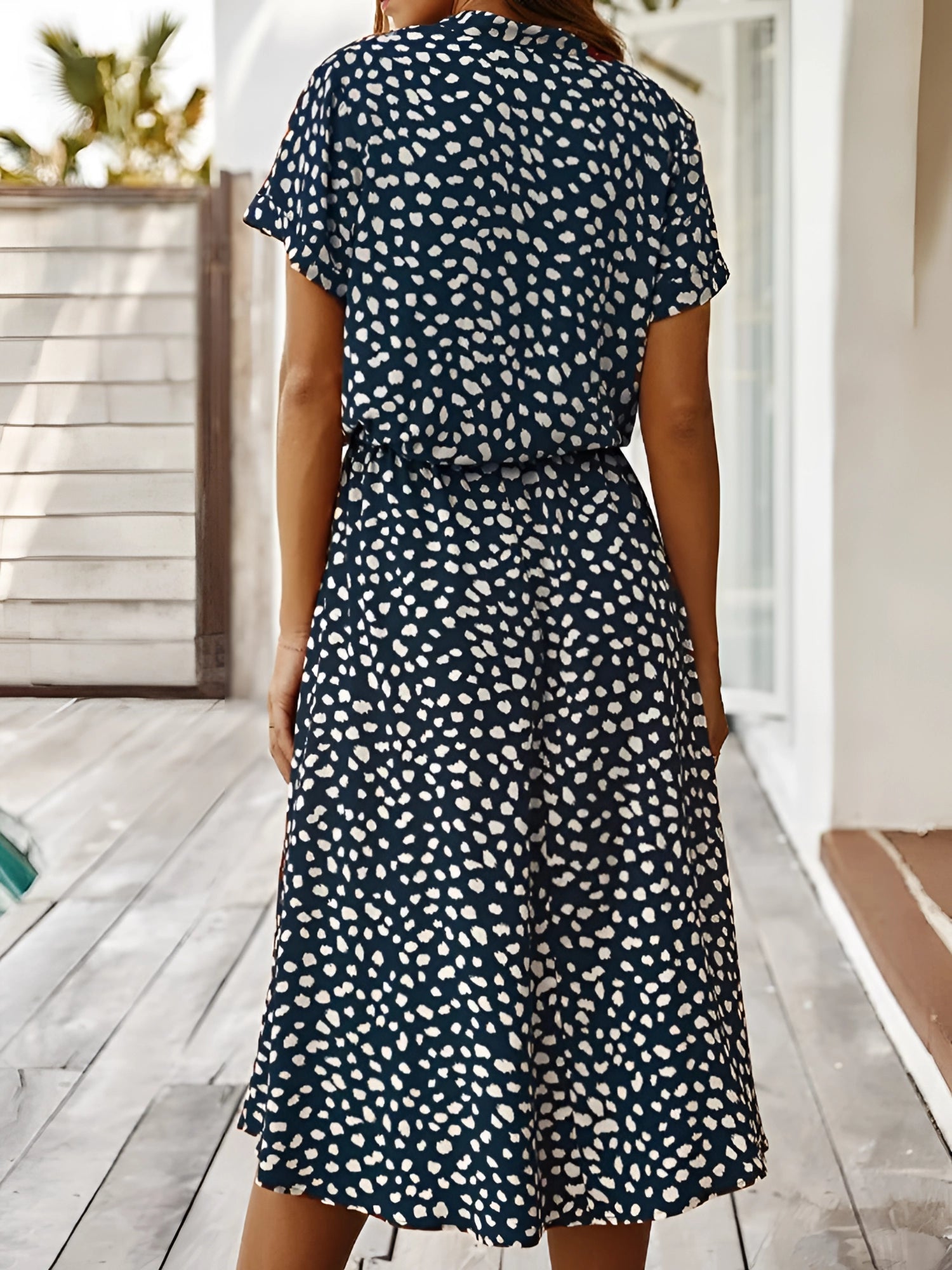 White polka dot midi dress with short sleeves, a tie waist, and lightweight fabric, perfect for summer.