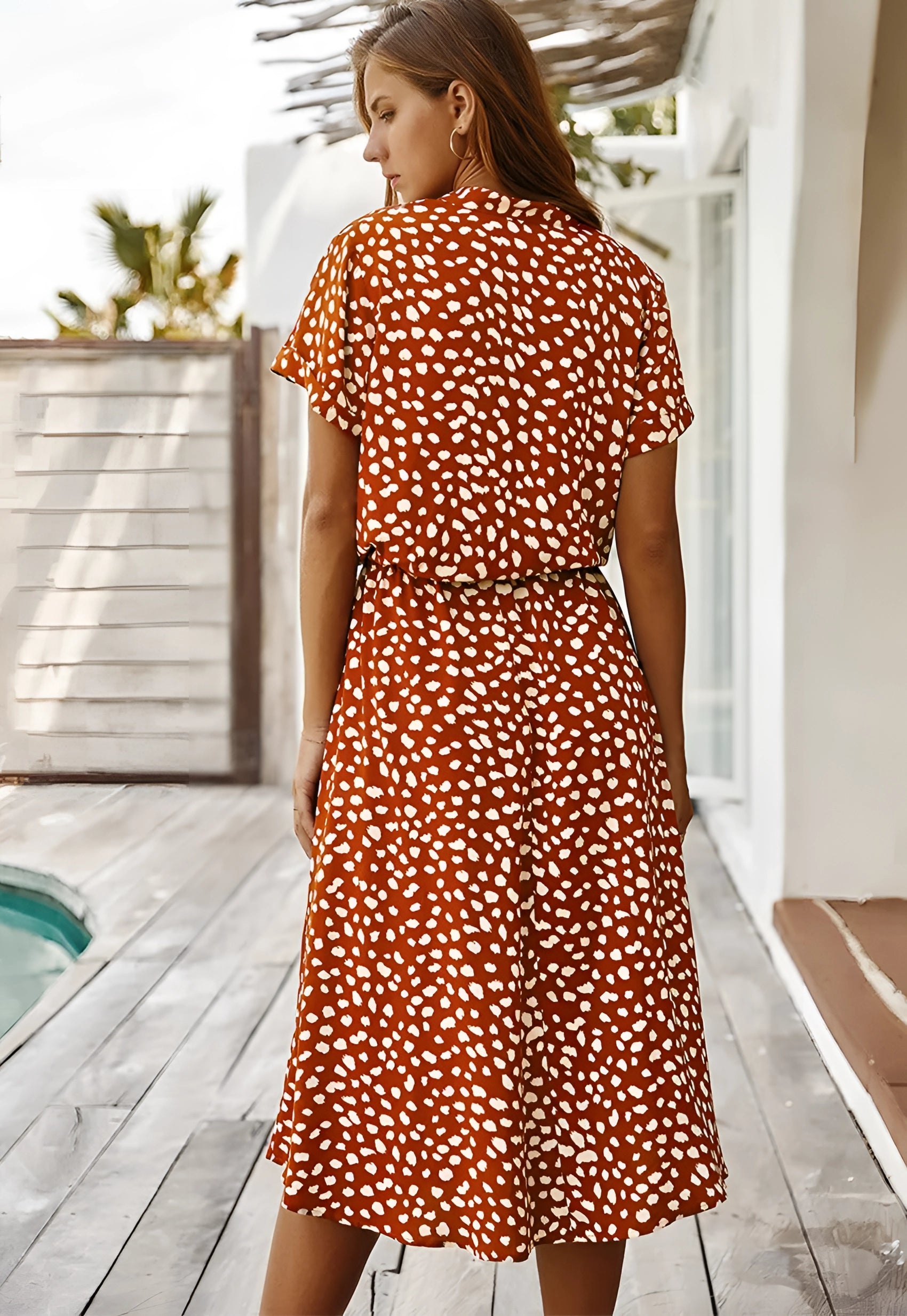 White polka dot midi dress with short sleeves and a tie waist, suitable for summer.