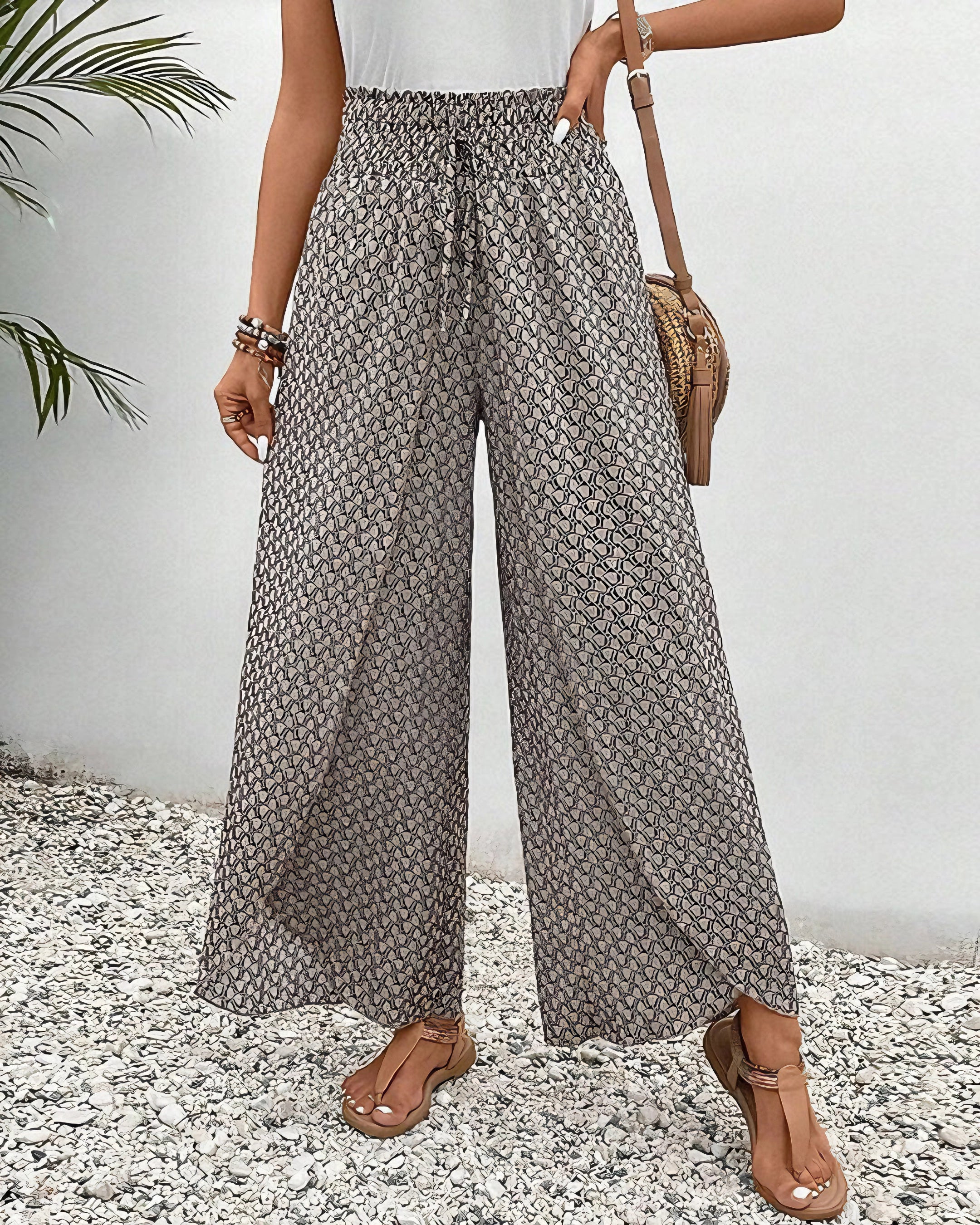 Gray high-waisted palazzo pants with red ethnic pattern, modeled outdoors in a boho summer beachwear style.