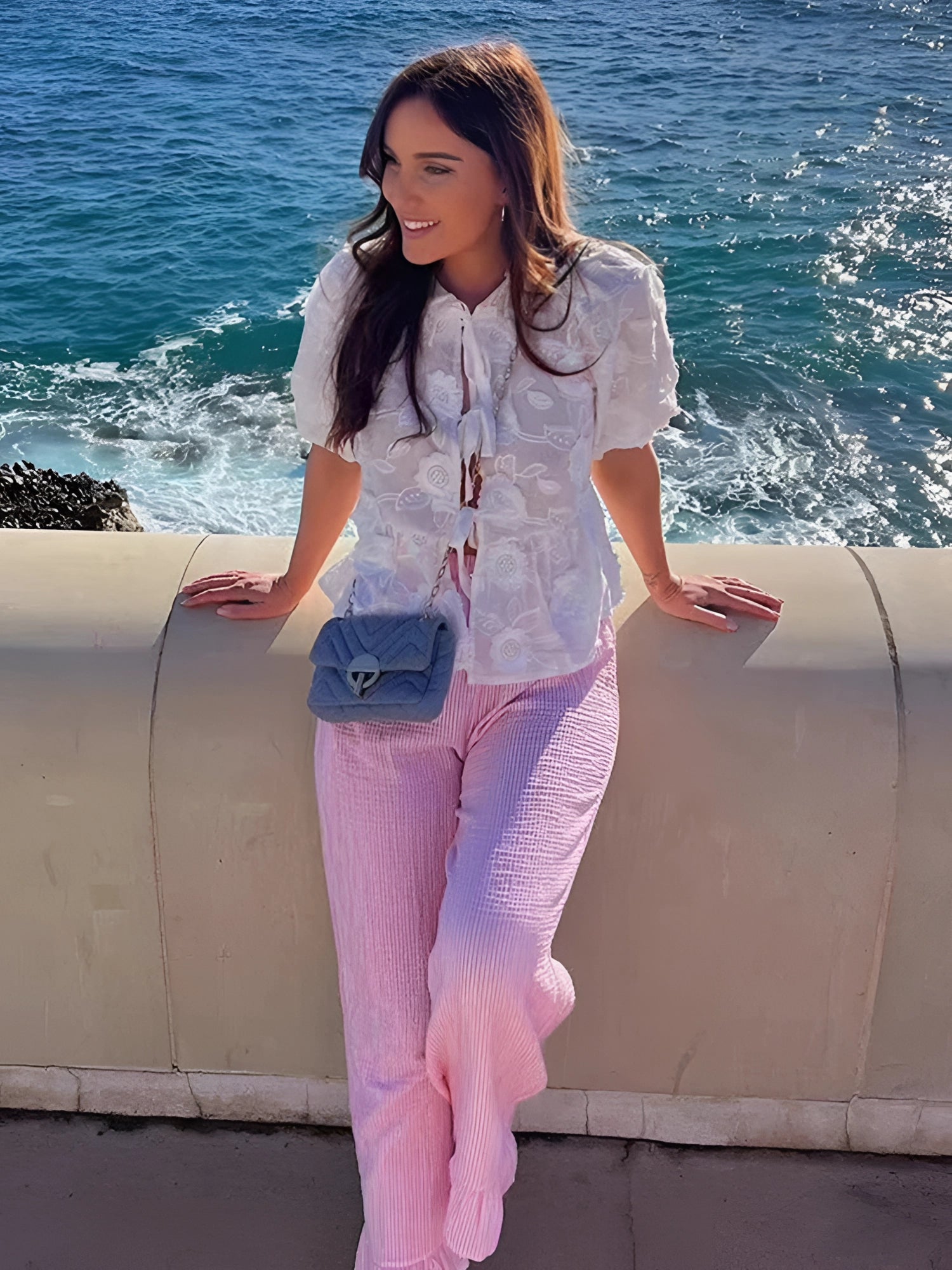 White lace tie-front blouse with sheer floral design, styled boho chic for summer, featuring long sleeves and worn by a model with a joyful expression.