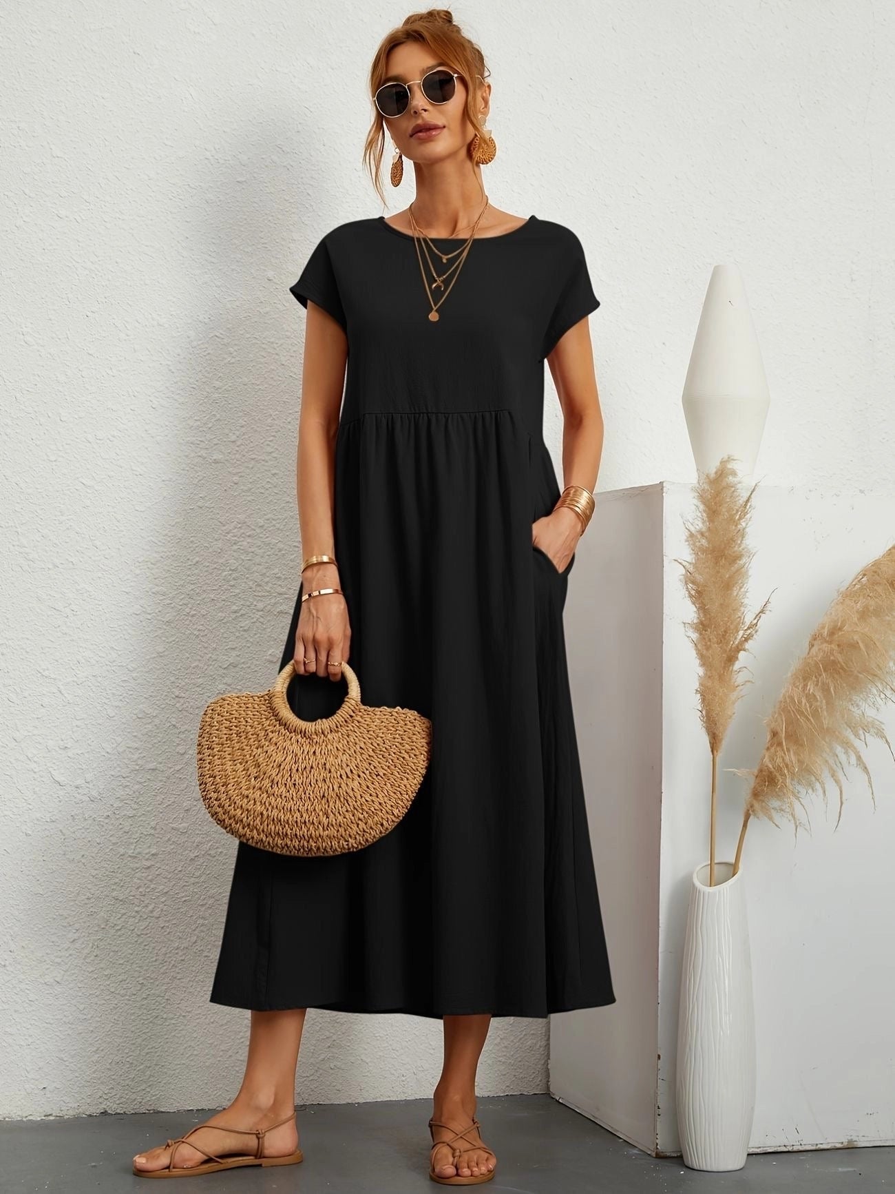 Woman wearing a black, short sleeve, crew neck midi dress, suitable for casual summer outings, in size 2XL.