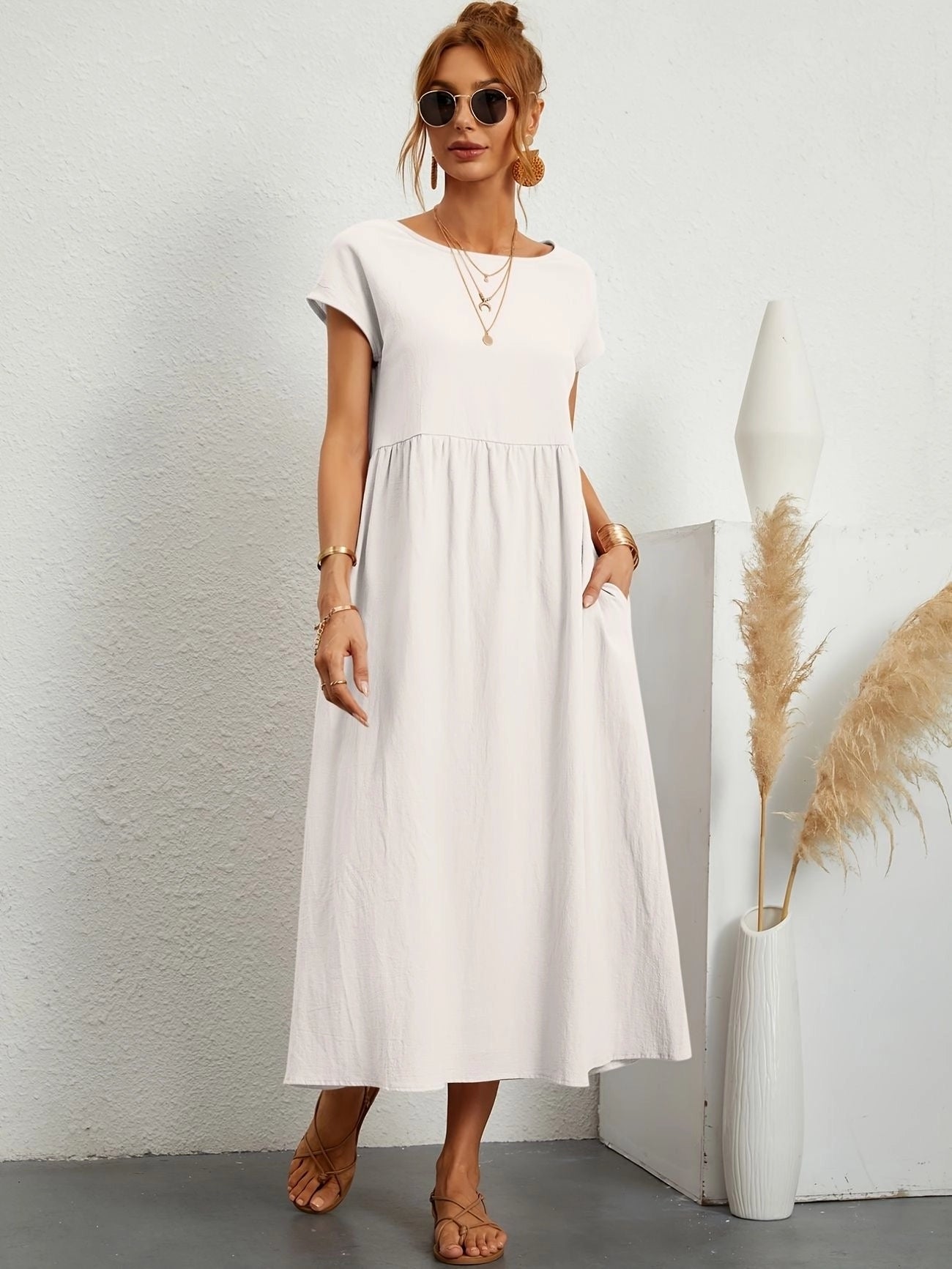 Woman wearing a white midi dress with short sleeves and a crew neck, perfect for casual summer outings.