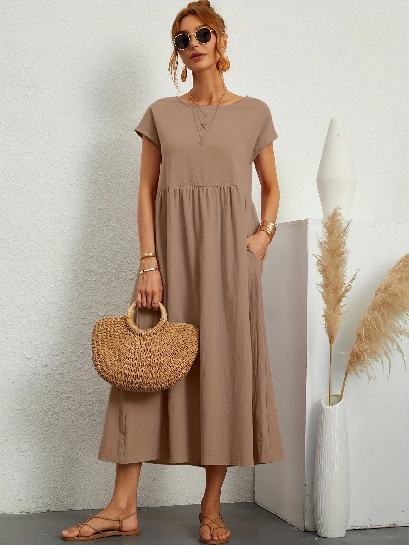 Woman wearing a white midi dress with short sleeves and a crew neck, featuring a casual summer design; dress is in khaki color and size 2XL.